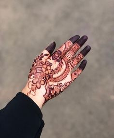 a woman's hand with henna tattoos on it