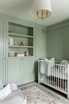 a baby's room with green walls and furniture