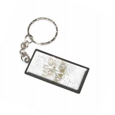 a keychain with a bird on it and flowers in the middle, sitting on a white surface