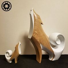 two white and wood sculptures sitting next to each other