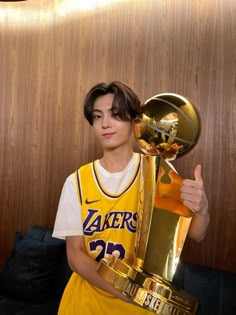 a young man holding up a basketball trophy