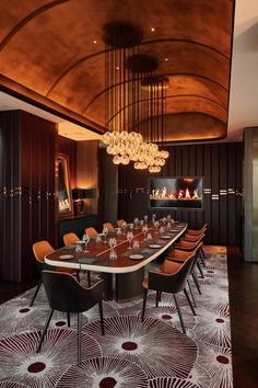 a dining room with a large table and chairs in front of a chandelier