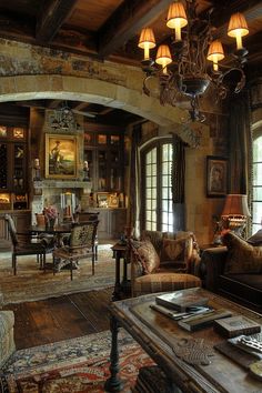 a living room filled with furniture and a chandelier hanging over the top of it