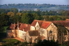 an aerial view of a church with trees and hills in the backgrouds