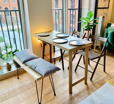 a dining room table with plates and place settings on it in front of a large window