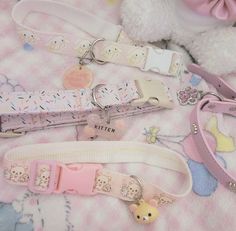 several different key chains on a blanket with a teddy bear