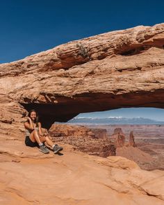 a woman sitting on top of a rock formation