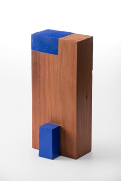 a wooden block with blue blocks sticking out of it's sides on a white background