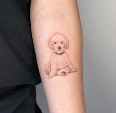 a small dog tattoo on the left forearm and arm, with a white poodle sitting next to it