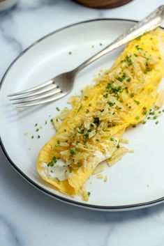 a white plate topped with an omelet covered in cheese and parmesan