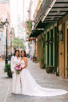 two brides posing for a photo on the street