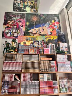 a bookshelf filled with lots of books next to a wall covered in pictures