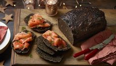 bread with smoked salmon on it sitting on a cutting board next to other food items