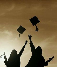 two people throwing graduation caps in the air