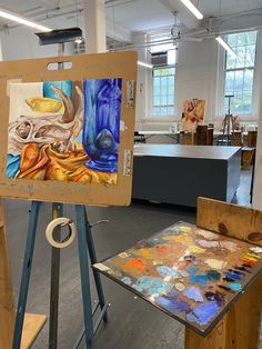 an artist's easel with paintings on it