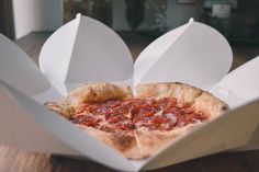 a pepperoni pizza in a box on a table