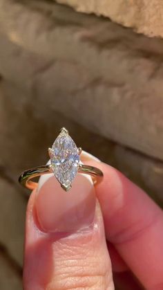 a person holding a ring with a diamond in it's middle finger and the other hand