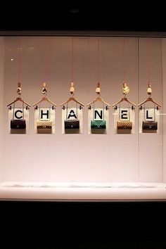 a display case with chanel bags hanging from it's sides