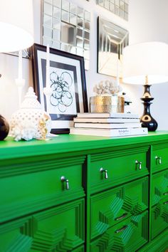 a green dresser topped with lots of drawers