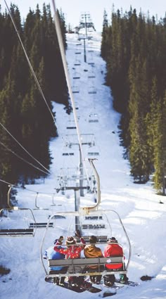 two people riding on a ski lift in the snow