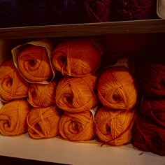 several balls of orange yarn sit on a shelf