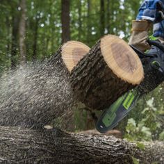 a man is using a chainsaw to cut down trees