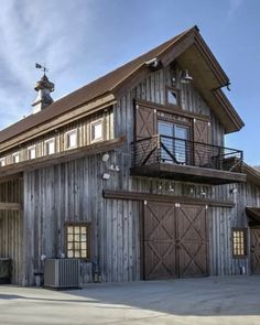 a large wooden building with two garages on the top and second story above it