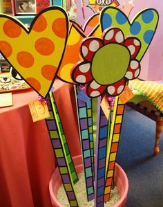 three colorful flowers are in a pot on the table