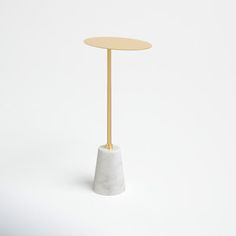 a small white table with a gold top and a round wooden stand on the side