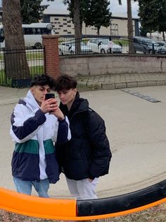 two people standing in front of an orange barricade