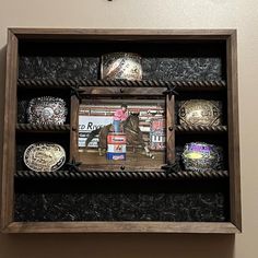 a wooden shelf with several different types of rings on it's front and sides