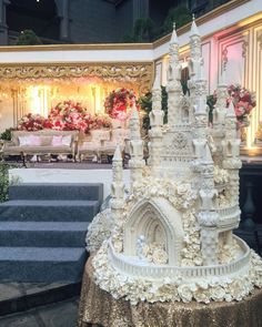 a cake that looks like a castle on top of a table in front of stairs