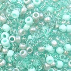 many different beads are shown in this close up photo, including light blue and white