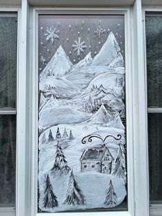 a window with a drawing of a snowy mountain scene on it