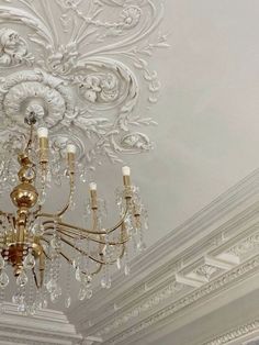 a chandelier hanging from the ceiling in a room with white walls and ceilings