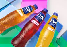 two bottles of fun are sitting next to each other on a colorful table cloth and plastic trays