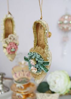 some ornaments are hanging from the ceiling in front of a wall with flowers on it