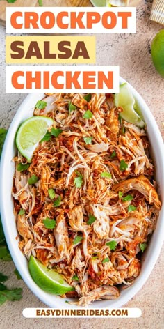 shredded chicken in a white bowl with limes and cilantro on the side