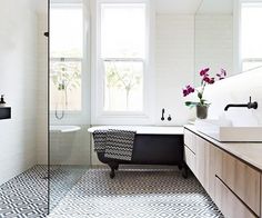 a bath room with a tub a sink and a window