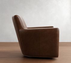 a brown leather chair sitting on top of a wooden table next to a white wall