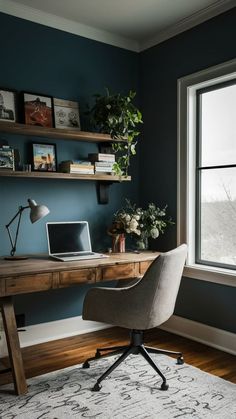 a desk with a laptop on it in front of a window and bookshelf