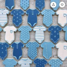 cookies decorated with blue and white onesuits are arranged on a wooden table top