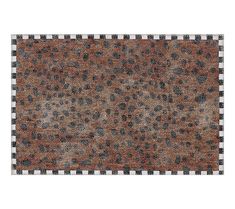 an animal print rug with black and white squares on the bottom, in front of a brown