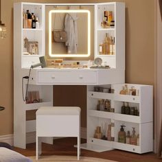 a white vanity with lighted mirror and stool in a room next to a wall mounted light