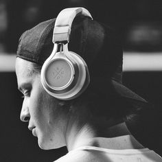 a person with headphones on their ears looking off to the side in black and white