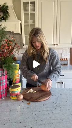 a woman cutting up food on top of a kitchen counter