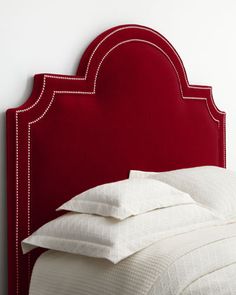 a red headboard with white pillows on it