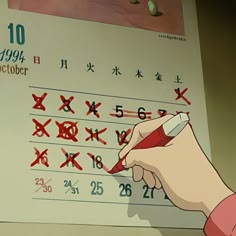 a person writing on a calendar with chinese characters