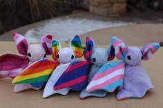 four stuffed animals are lined up in a row on a table with snow behind them