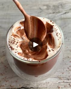 a glass jar filled with chocolate pudding and topped with a wooden spoon on top of it